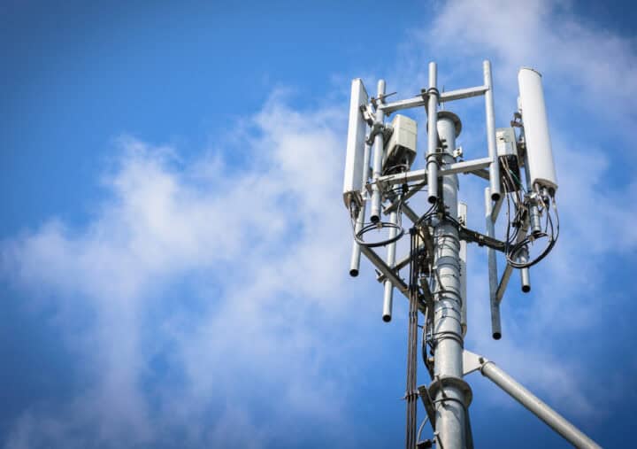 A sizable cable spool in green and white, positioned on the ground, emphasizing its large diameter and color scheme.